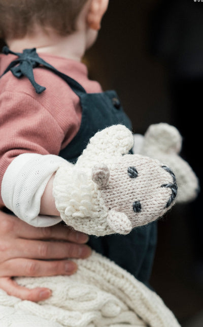 merino wool.colour natural.kids mittens.handknit.sheep smiley face and ears on main body of mitten.a tuft of sheep hair knitted above smiley face.