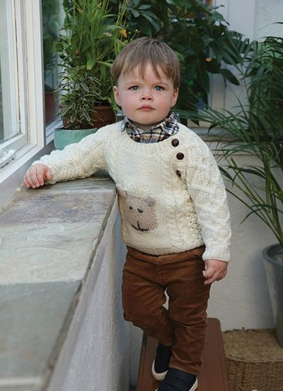 Hand kids aran sweater, colour natural. cute sheep face on front in oatmeal colour, Aran stitches . 3 brown traditional buttons on right side from neck to under arm .
