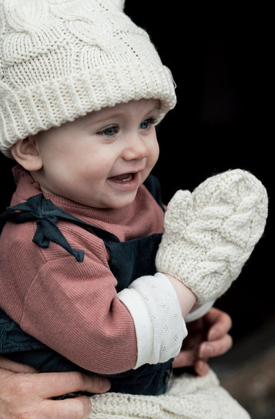 Hand knit hat with pompom and mitten set made of extra soft merino wool. colour natural . Aran stitches  on both.