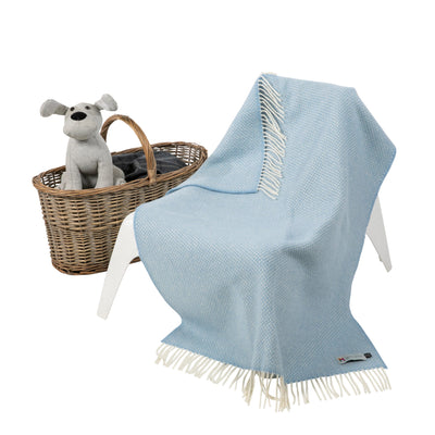 Blue herringbone baby blanket with white wool fringing on 2 shorter ends.