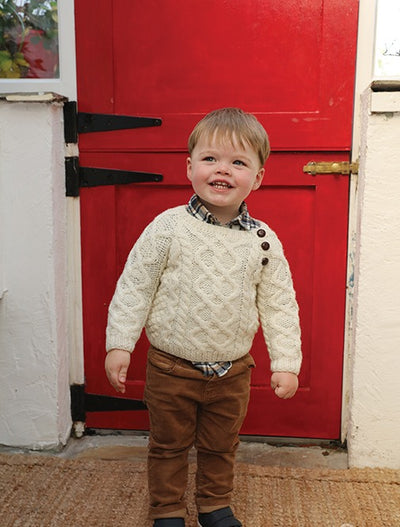 extra soft. Handknit kids aran seater. Trellis stitch on main body and arms. blackberry stitch on 2 side panels. cable stitch featured . colour natural.