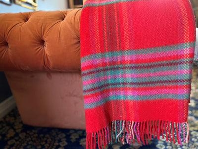 cashmere and wool mix Throw. Wool fringing on two ends. Main colour is Vibrant red with green pink and pale orange with maroon Horizontal and vertical stripes.136cm x 180cm